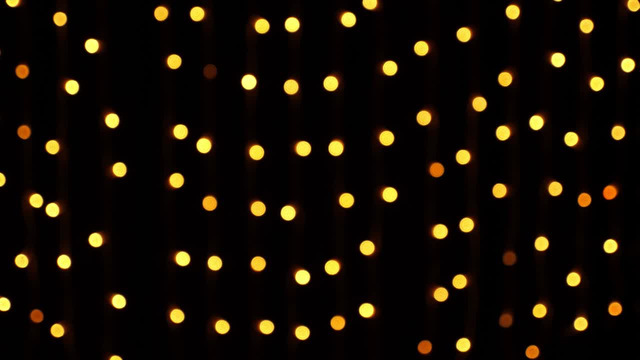 Abstract bokeh background in motion. shining, blurred golden particles, lights. bright bokeh from garlands on dark background. New year or Christmas festive backdrop