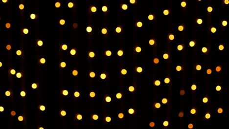 Abstract bokeh background in motion. shining, blurred golden particles, lights. bright bokeh from garlands on dark background. New year or Christmas festive backdrop