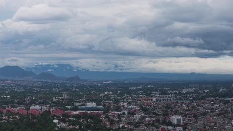 aerial perspective of mexico city under a sky full of grey clouds, during a rainy season afternoon