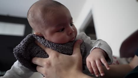 Father-Using-Towel-To-Gently-Hold-His-2-Month-Old-Son-On-The-Front-To-Help-Him-Burp-After-Drinking-Milk