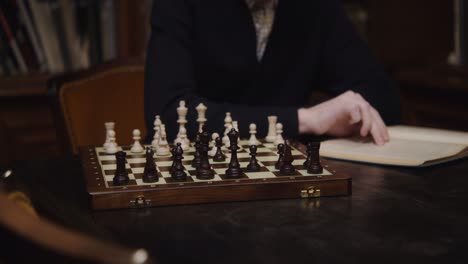 hombre jugando al ajedrez en una biblioteca