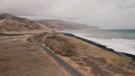 coastal road and black sand beach in new zealand