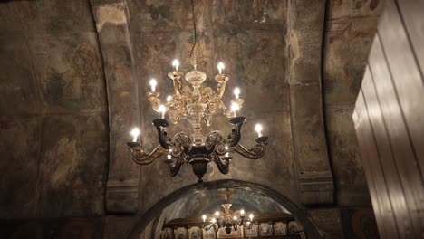 Innenraum-Einer-Wunderschönen-Alten-Kirche-Mit-Einem-Großen-Goldenen-Kronleuchter,-Der-Von-Der-Decke-Hängt