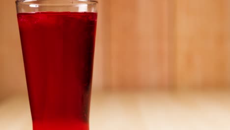 a glass filled with red soft drink