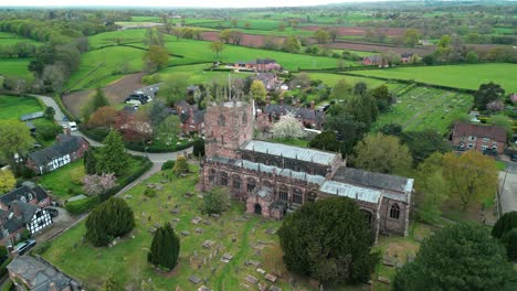 St-Boniface,-Bunbury,-Cheshire---a-quintessential-English-village-Church---Aerial-drone-clockwise-pan-and-countryside-reveal,-May-23