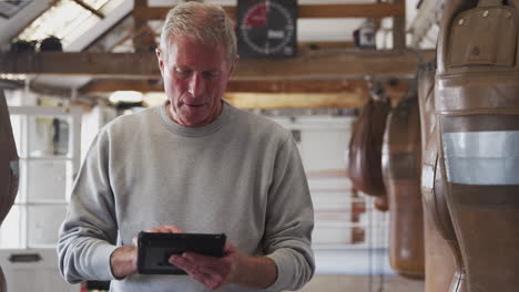 Entrenador-De-Boxeo-Masculino-Senior-En-Entrenamiento-De-Seguimiento-De-Gimnasio-Usando-Tableta-Digital