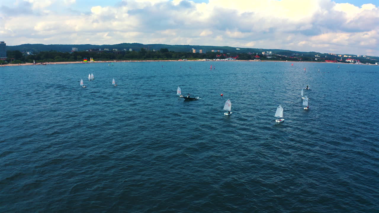 bote optimista navegando en las aguas azules del mar báltico cerca de la orilla en un día de vacaciones soleado