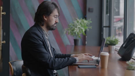 hombre de negocios trabajando en una computadora portátil en un café