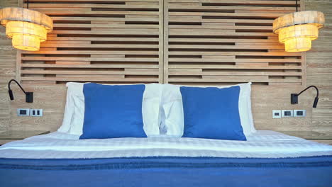 pedestal down of tidy and clean white and blue double bed in hotel room