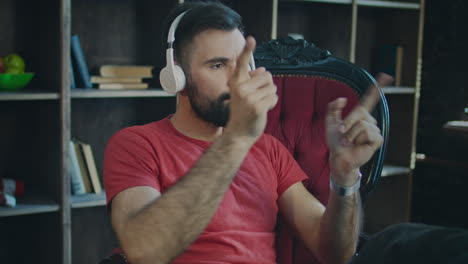 businessman listening music in headphones in home office. dancing at work