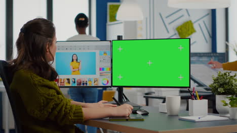 woman retoucher working on photo set using green screen display