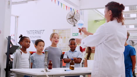 niños de la escuela viendo un experimento de química en el centro de ciencias.