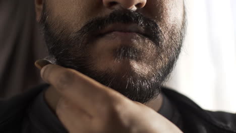 close up of ethnic minority adult male combing beard