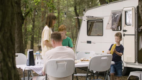 happy family having breakfast at the camping in the forest