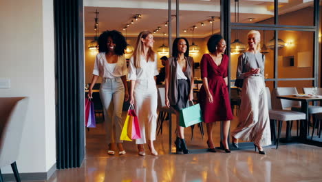 diverse group of women walking with shopping bags in an upscale interior