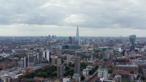 Volar-Hacia-Atrás-Sobre-La-Ciudad.-Vista-Panorámica-Aérea-Del-Barrio-Urbano-Y-Rascacielos-Altos-En-La-Distancia.-Londres,-Reino-Unido