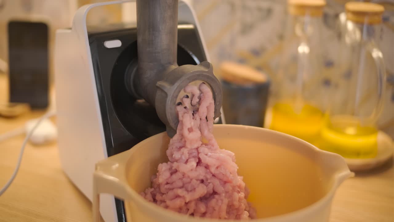 Tritacarne elettrico che prepara carne macinata in cucina
