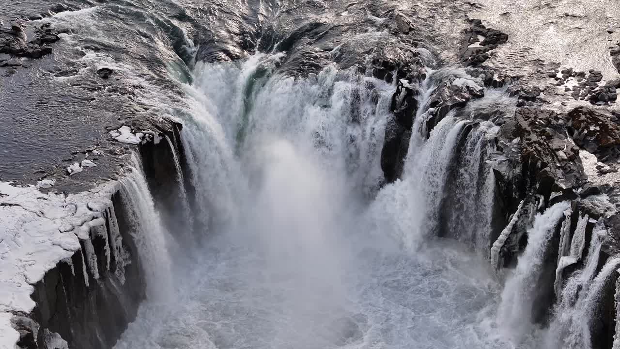 Multiple river cascades plunge powerfully over rugged basalt cliffs near Selfoss, Iceland, forming an icy, dramatic amphitheater of roaring winter waterfalls.
