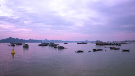 majestic limestone karsts silhouette against a lavender-tinted sky while traditional vietnamese fishing trawlers drift serenely on the tranquil waters of ha long bay at twilight