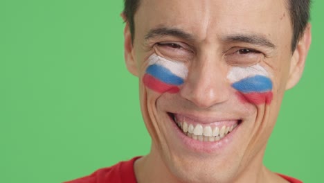 Man with a russian flag painted on the face smiling