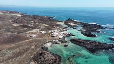 A-beautiful-clear-aerial-view-circling-the-spanning-rugged-turquoise-coastline-of-the-Island-of-Wolves,-Spain