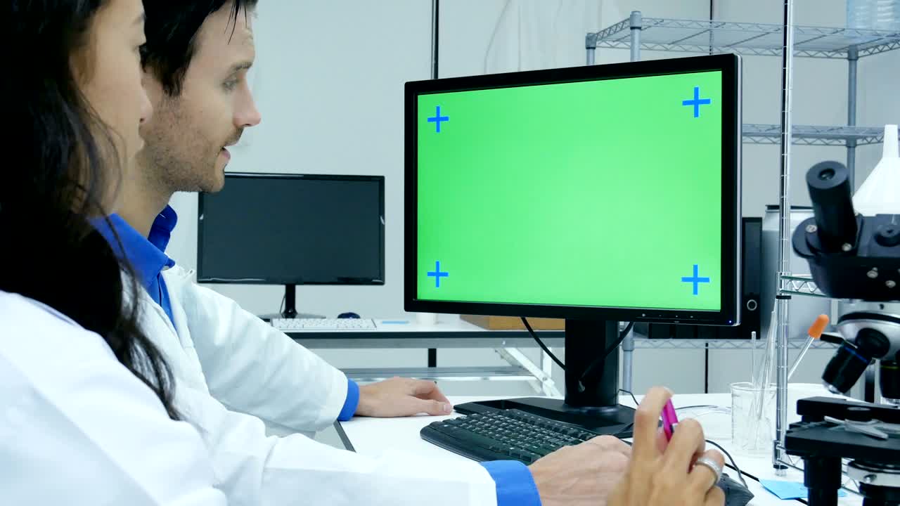 científicos o químicos que usan computadoras para el trabajo. marcación de pantalla verde en el escritorio. resolución 4k.