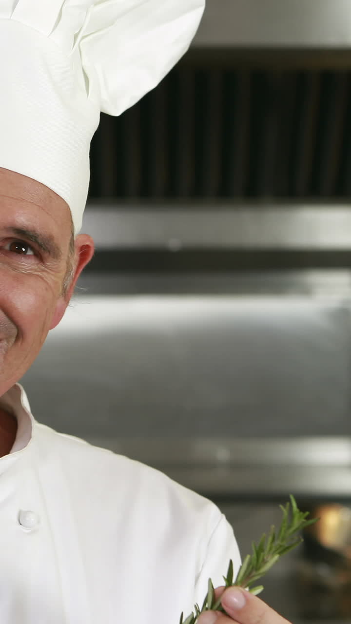 guapo chef con olor a romero y haciendo un signo de ok