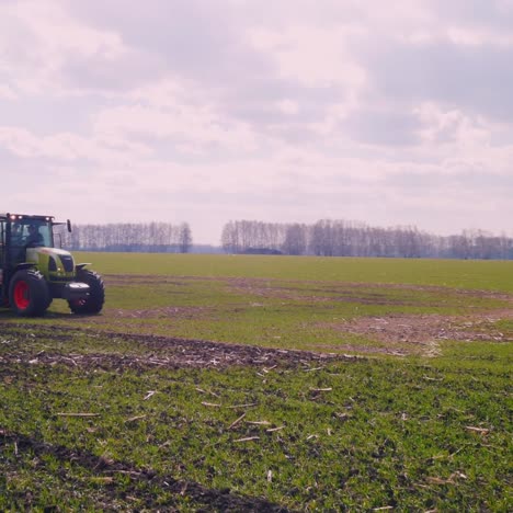 a picturesque landscape - a tractor in the field in the spring cultivates the earth 4