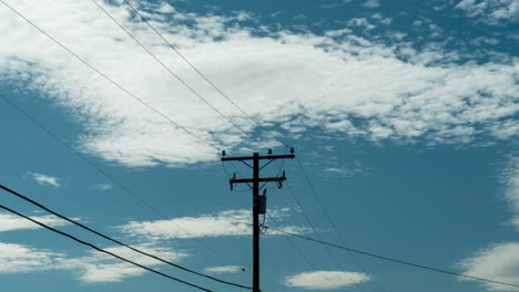 白雲漂移在藍天上的電柱和電線旁邊