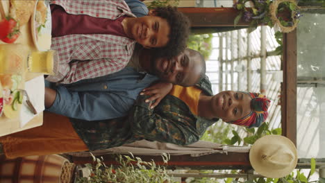 Portrait-of-Joyous-Afro-Family-at-Dinner-Table-in-Greenhouse