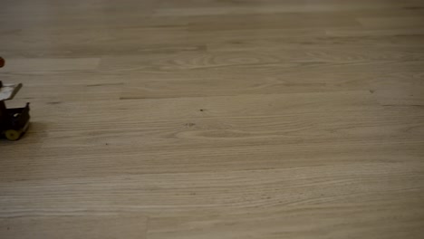 vintage toy train being pulled on a string on a wooden floor - isolated close up