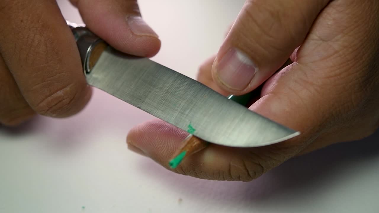 imágenes de manos afilando lentamente un lápiz y algunos lápices de colores con un cuchillo afilado