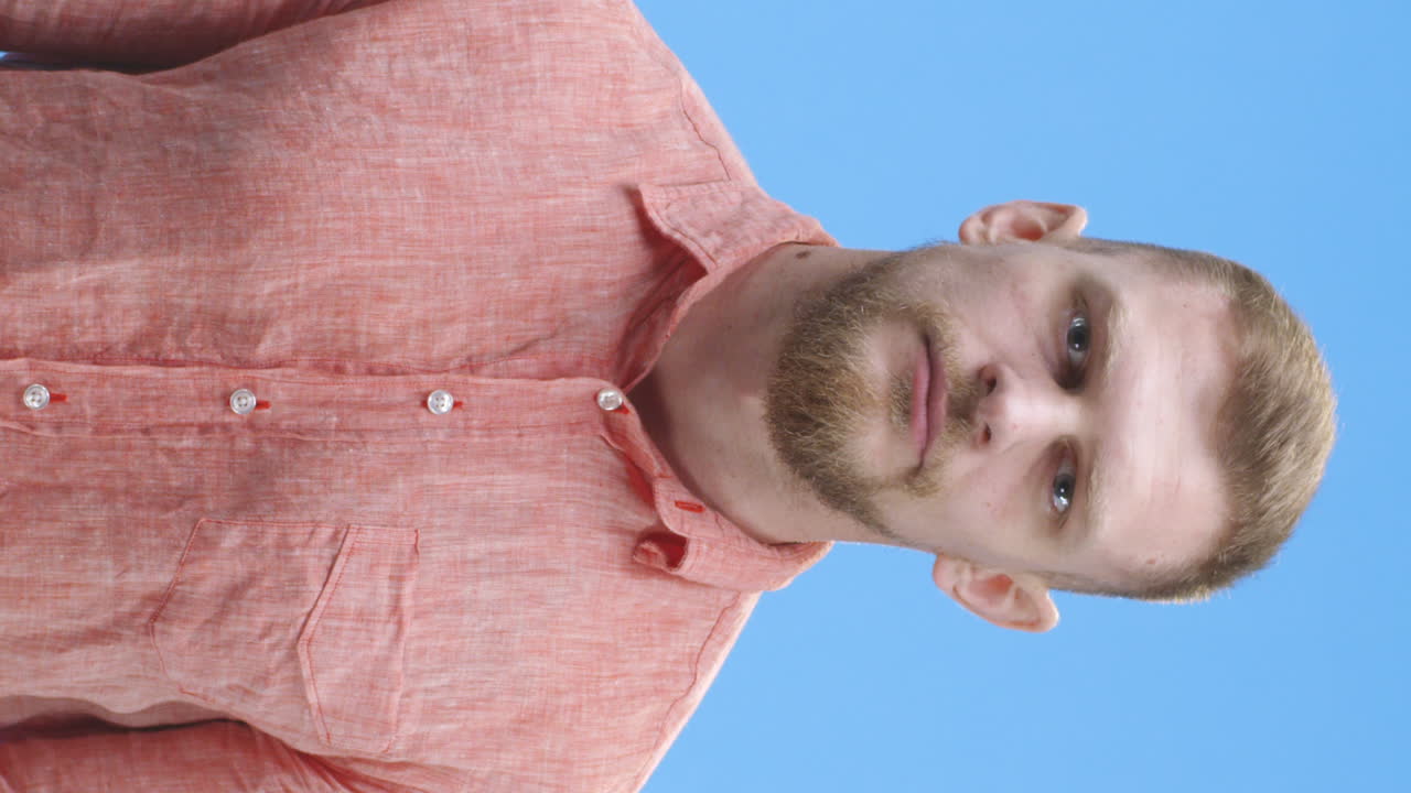 Man with a reddish shirt, covering his eyes