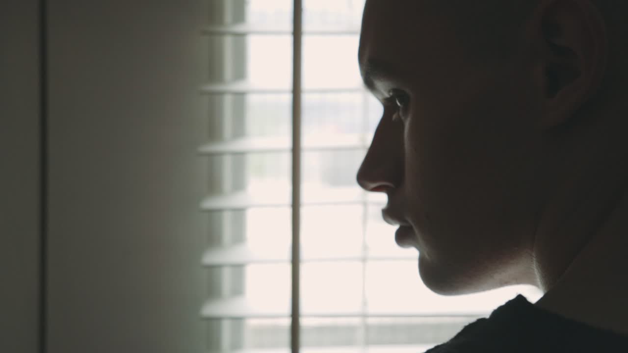Caucasian Man Standing By The Window With White Venetian Blinds - close up