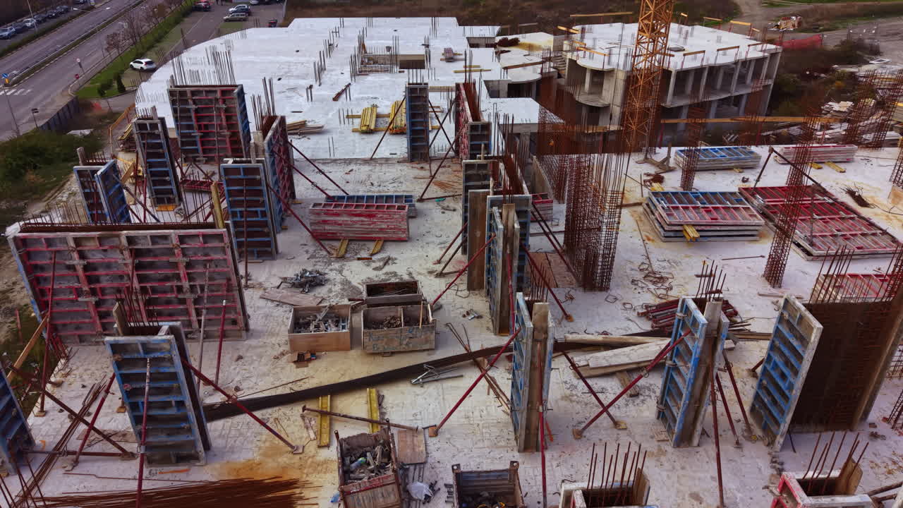 Construction site buzzes with activity as workers build a new structure surrounded by modern machinery and equipment during the day in a bustling urban area
