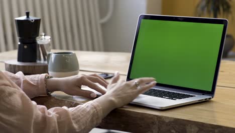 mujer trabajando en una computadora portátil en una mesa de madera