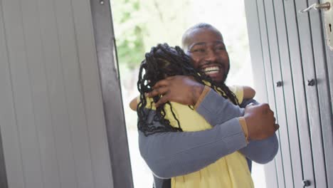 Happy-african-american-daughter-and-father-hugging-in-doors