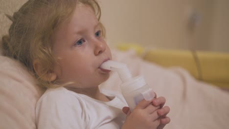 upset girl breathes with inhaler to cure cough in bed