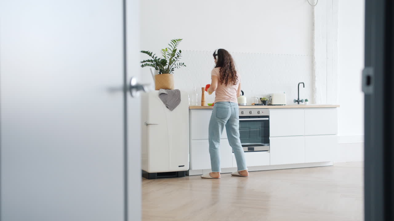 Donna che balla e canta in una cucina moderna