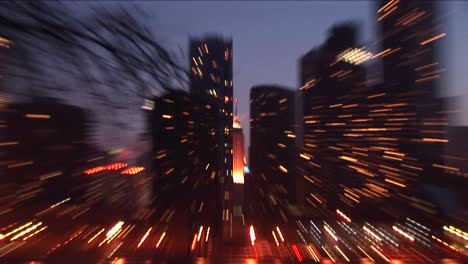 Die-Kamera-Zoomt-Die-Spitze-Eines-Beleuchteten-Hochhausturms-Aus-Einer-Weitwinkelansicht-Der-Skyline-Von-Chicago-Heran