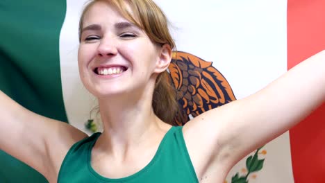 joven mexicana celebrando mientras sostiene la bandera de méxico en cámara lenta