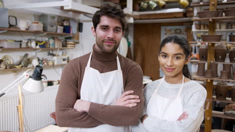 portrait of young couple wearing aprons running pottery and ceramics studio