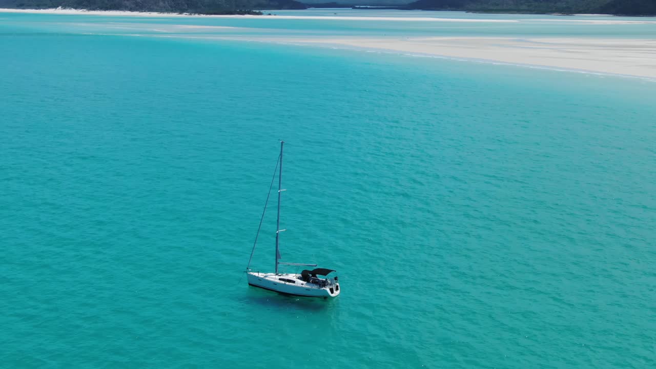 velero blanco se sienta anclado en aguas claras y verdes frente a la costa de queenslands whitehaven beach, australia, antena de drones