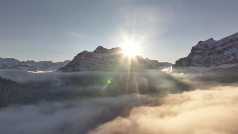 sun rising behind rautispitz in the glärnisch mountain range, part of the swiss alps, creating a stunning natural scene.