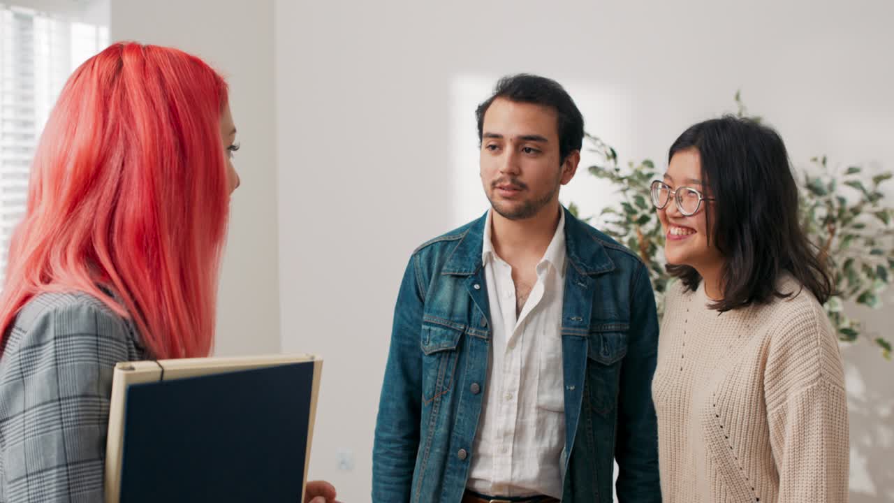 viendo apartamento para venta, alquiler a inquilinos potenciales, pareja joven está hablando en la habitación con el agente de bienes raíces, están discutiendo haciendo preguntas negociando precio mujer está tratando de dar respuestas