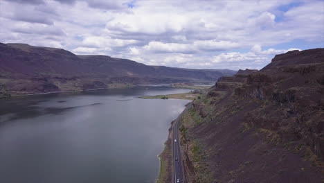 rising aerial reveals highway traffic along lenore lake in central wa