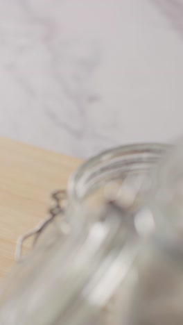 vertical video shot of freshly baked loaf of bread being put down onto marble work surface