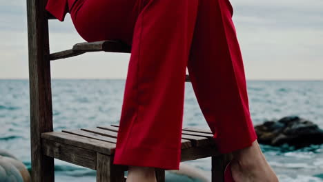 woman in a red suit on a rocky beach by the sea