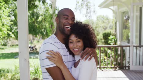 Mixed-race-couple-hugging-each-other-in-a-garden-