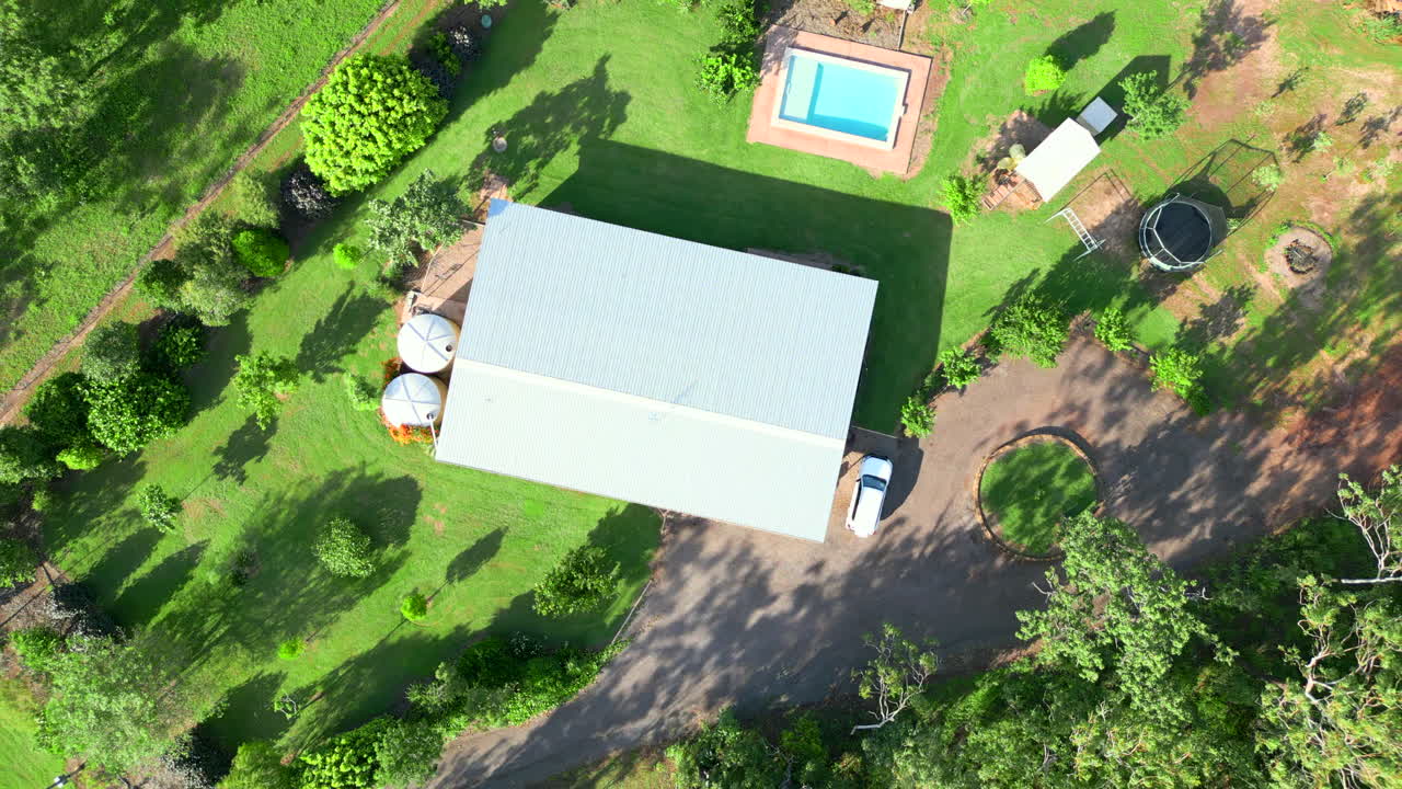 시골 부지의 집과 함께 시골 부지에 있는 농촌 부지의 공중 드론, 수영장과 회전로, 위에서 아래로 내려가 회전